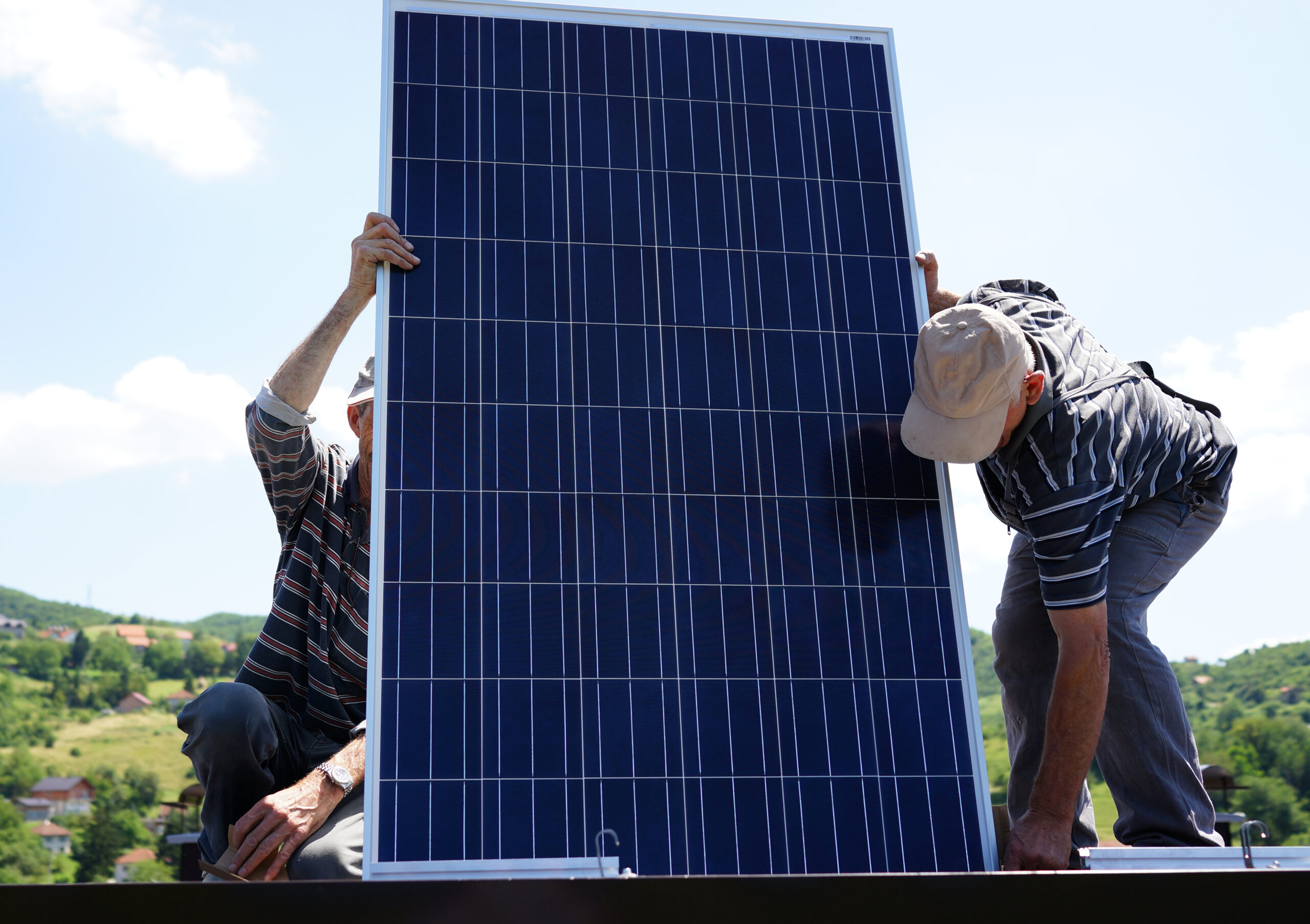 Man installing alternative energy photovoltaic solar panels on r